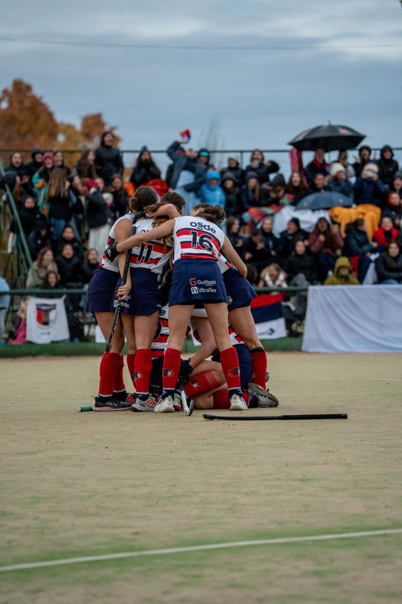 El equipo de hockey de Marista festejando en la cancha, con la tribuna llena